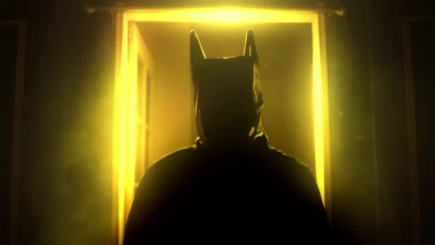 Batman-inspired silhouette in a yellow-lit doorway